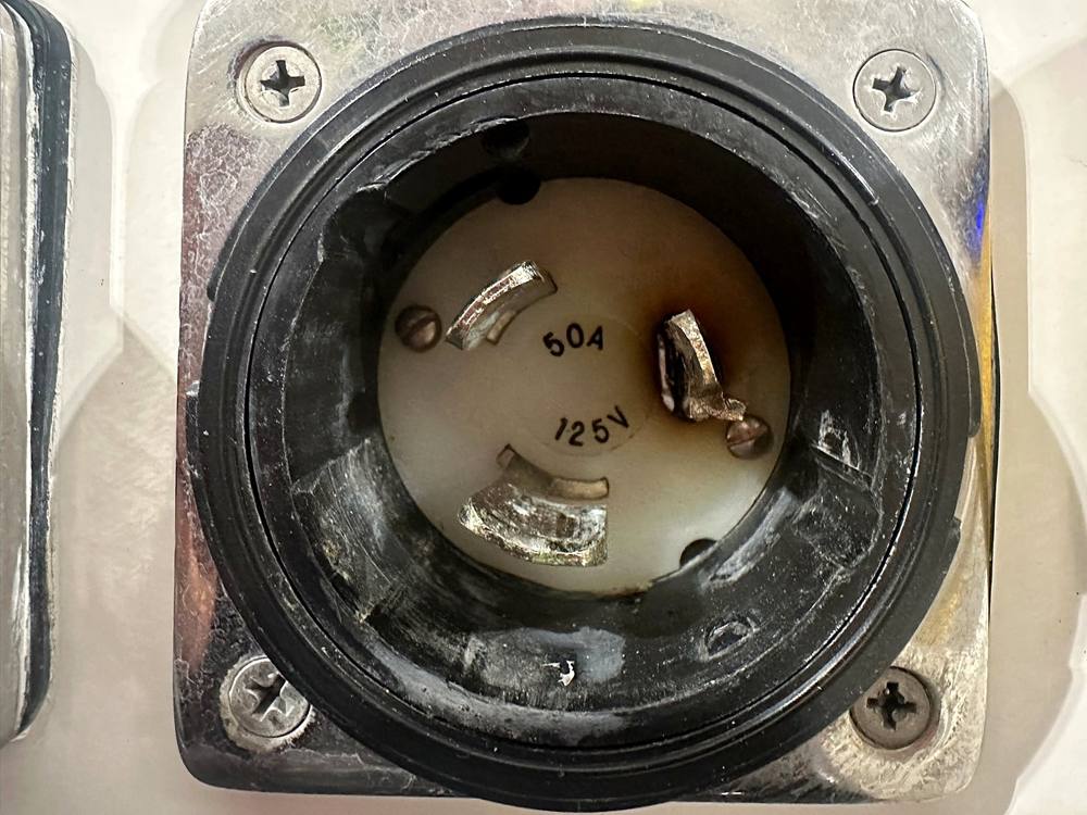 A 50 amp boat inlet with heat damage on its pins